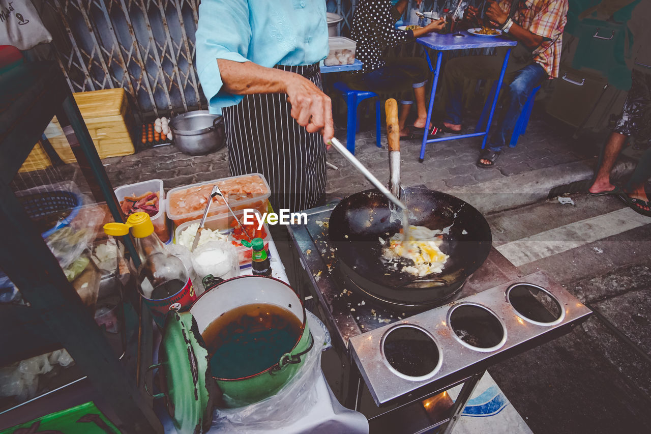 HIGH ANGLE VIEW OF MAN PREPARING FOOD ON TABLE