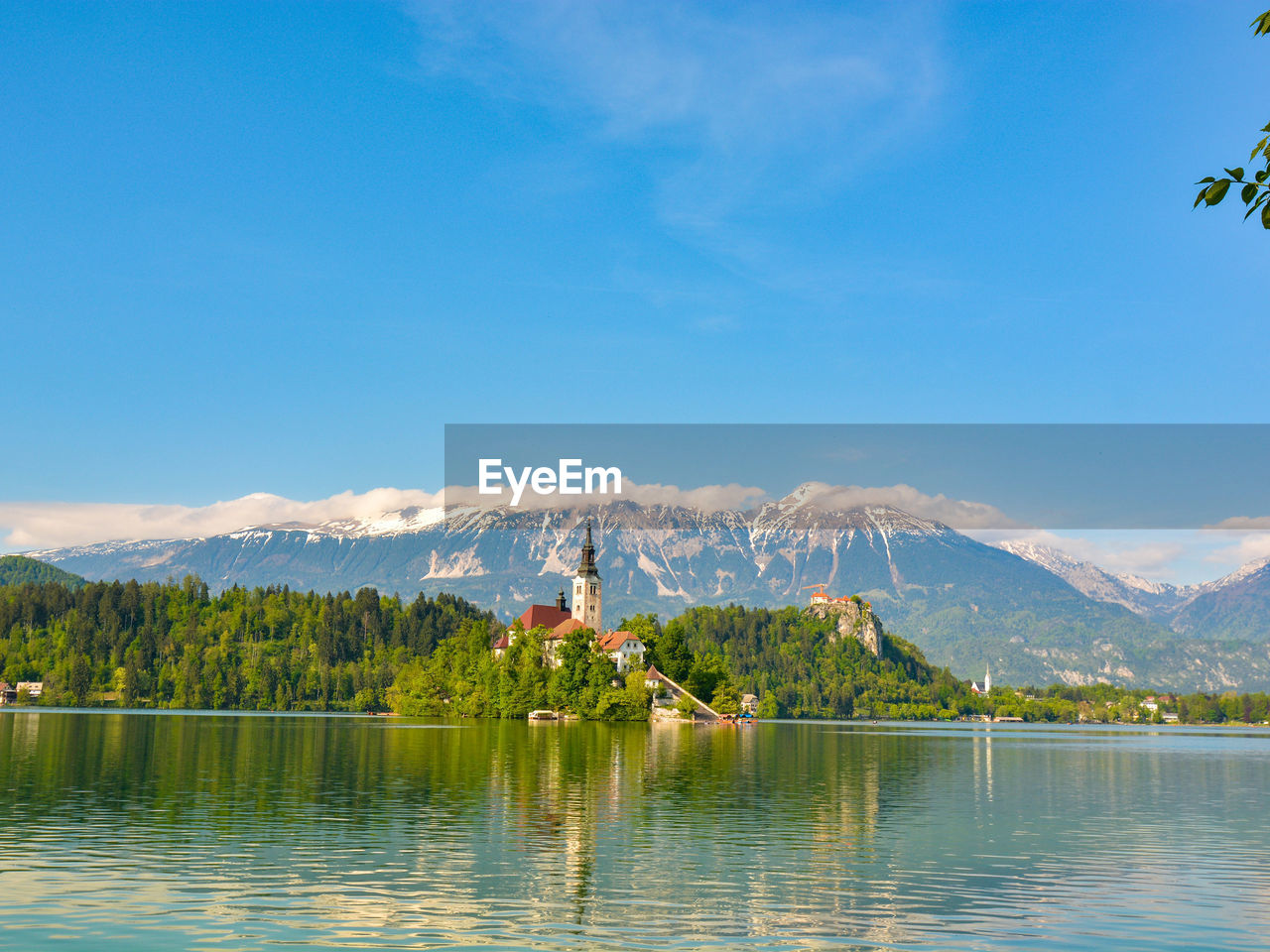 Scenic view of lake and mountains against blue sky