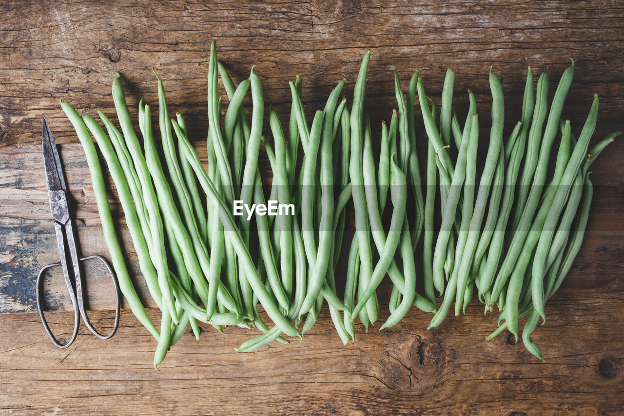 High angle view of green beans on wooden table