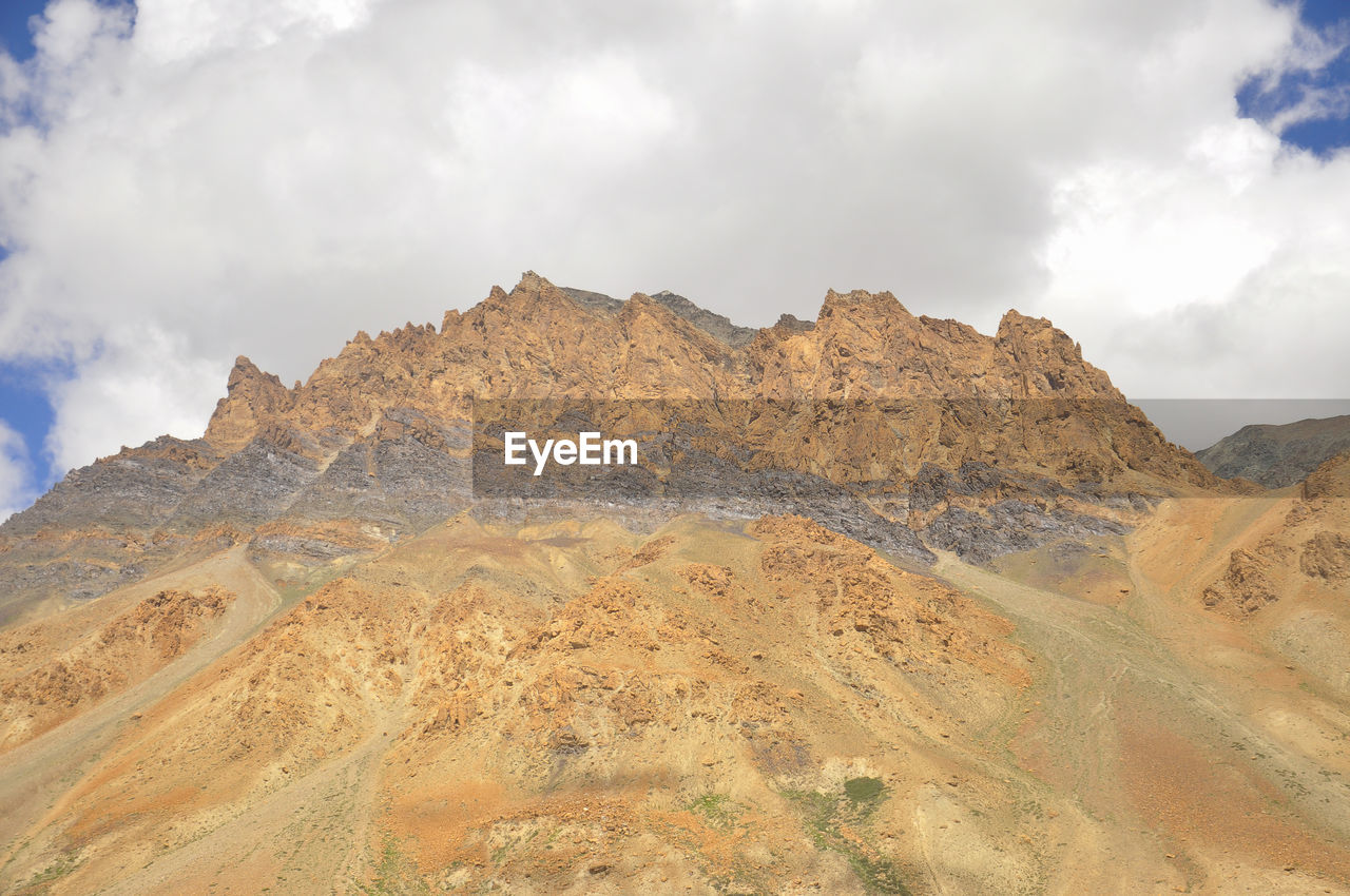 Brown rocky mountain with cloudy sky on the way of darcha-padum road, ladakh, india 