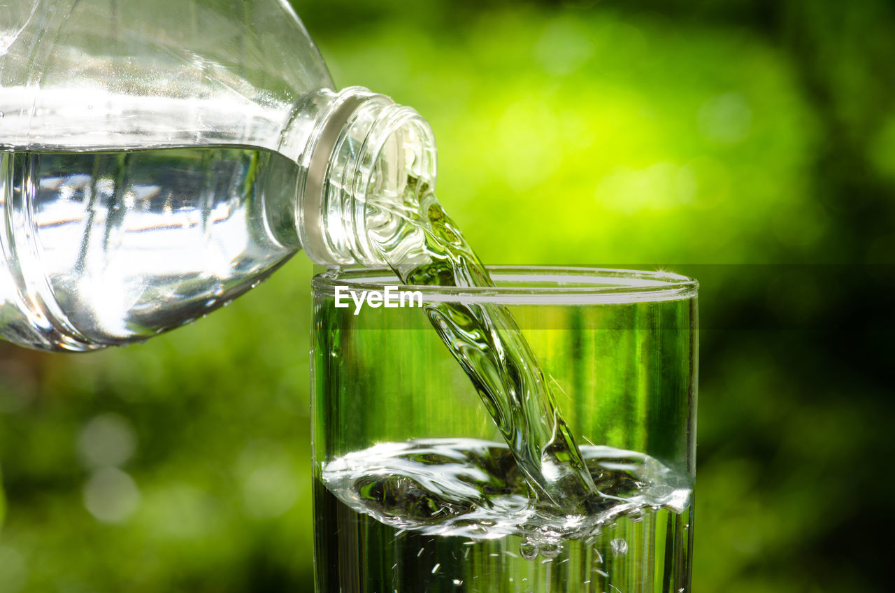 green, glass, refreshment, water, drinking glass, food and drink, focus on foreground, drink, close-up, nature, alcoholic beverage, no people, household equipment, transparent, freshness, drinkware, wine glass, outdoors, reflection, macro photography, plant, wine, day, drinking water, distilled beverage, stemware, grass, food