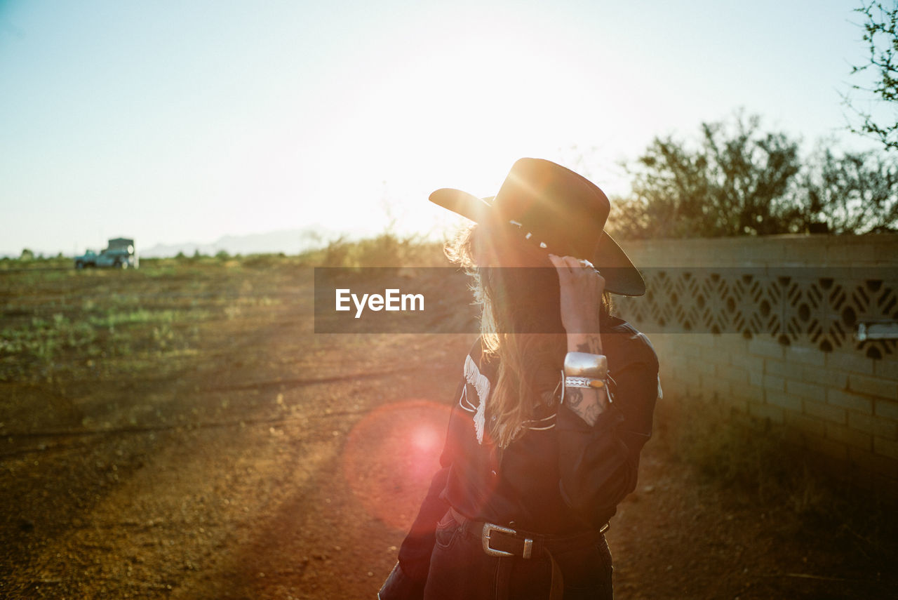 Woman in cowboy hat with sun flare