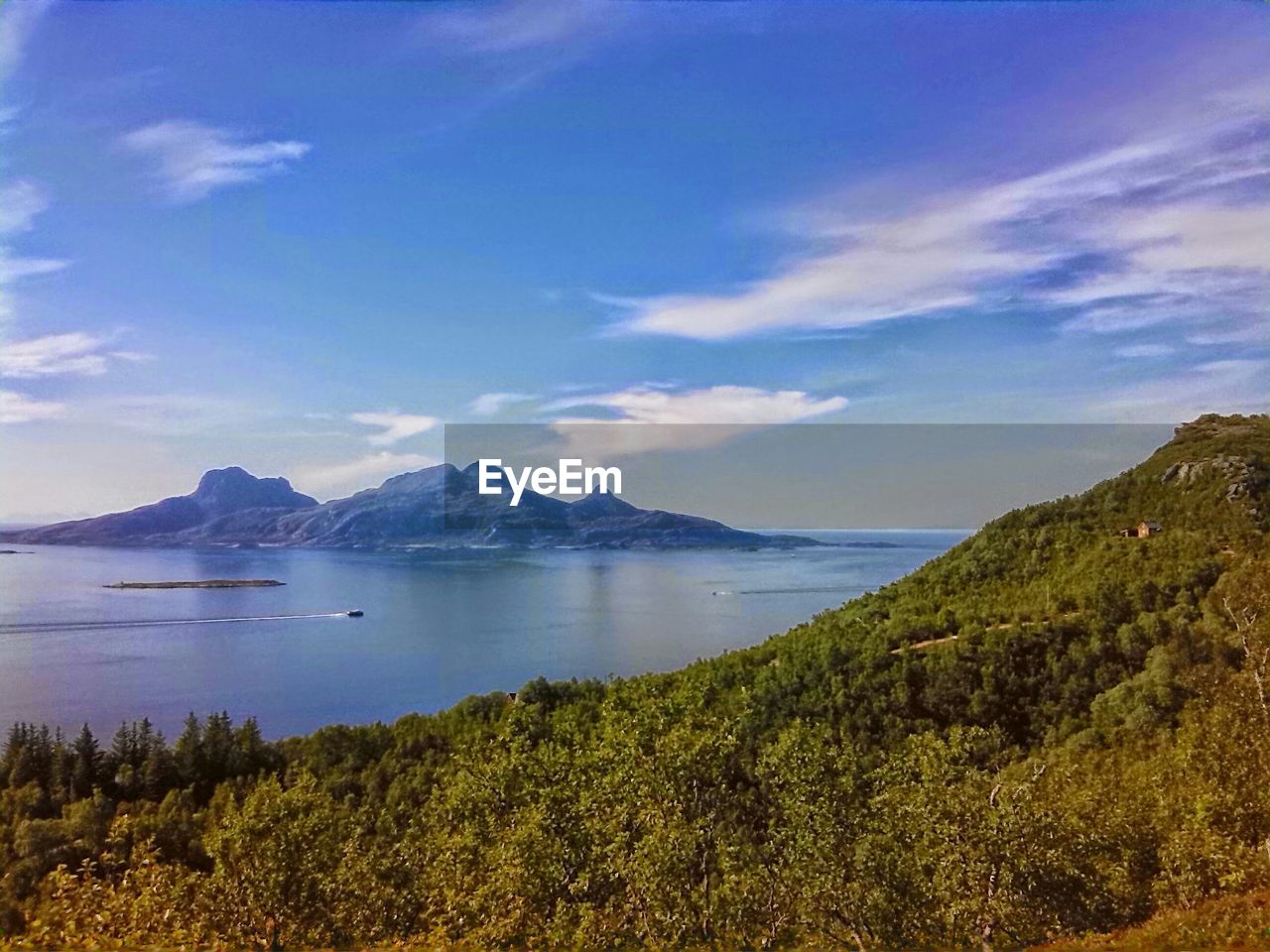 Green mountains and lake against sky