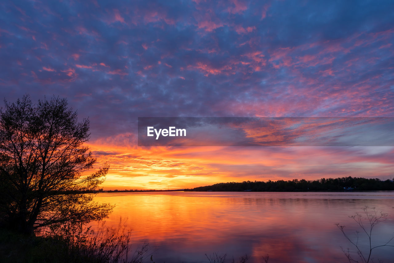 SCENIC VIEW OF LAKE AGAINST ORANGE SKY