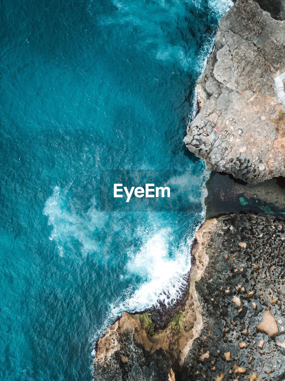 Directly above shot of waves rushing on rocks at beach