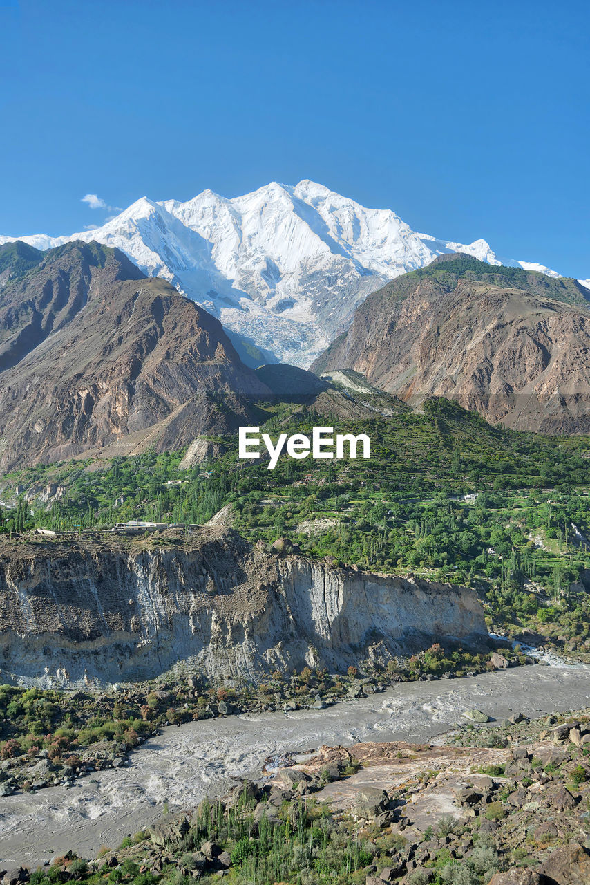 Scenic view of snowcapped mountains against blue sky