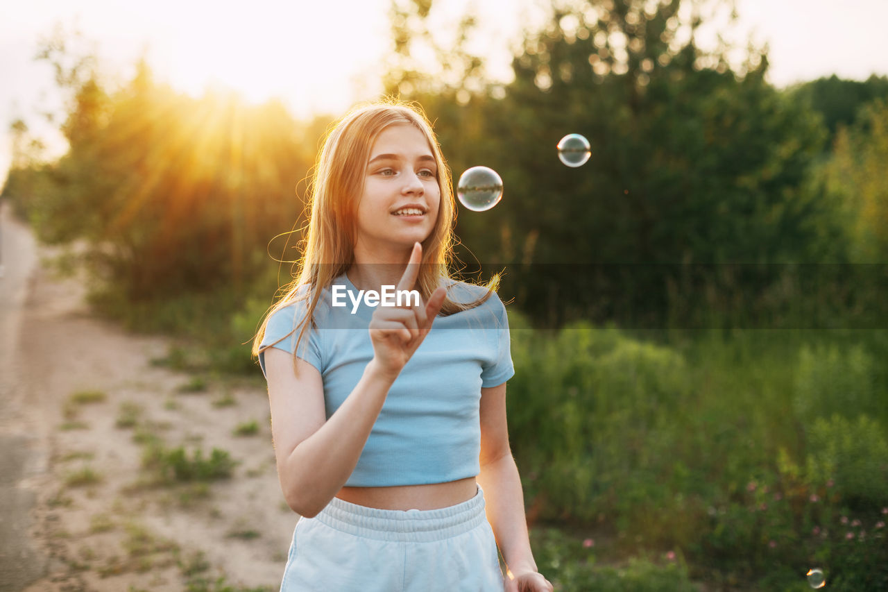 Cute girl making bubble outdoors