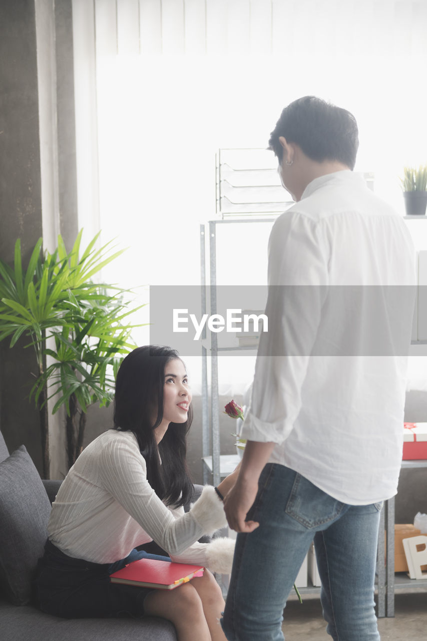 Man giving rose to woman at office