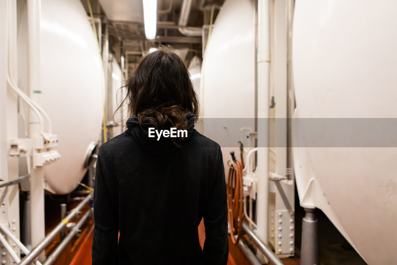 Rear view of woman standing in factory