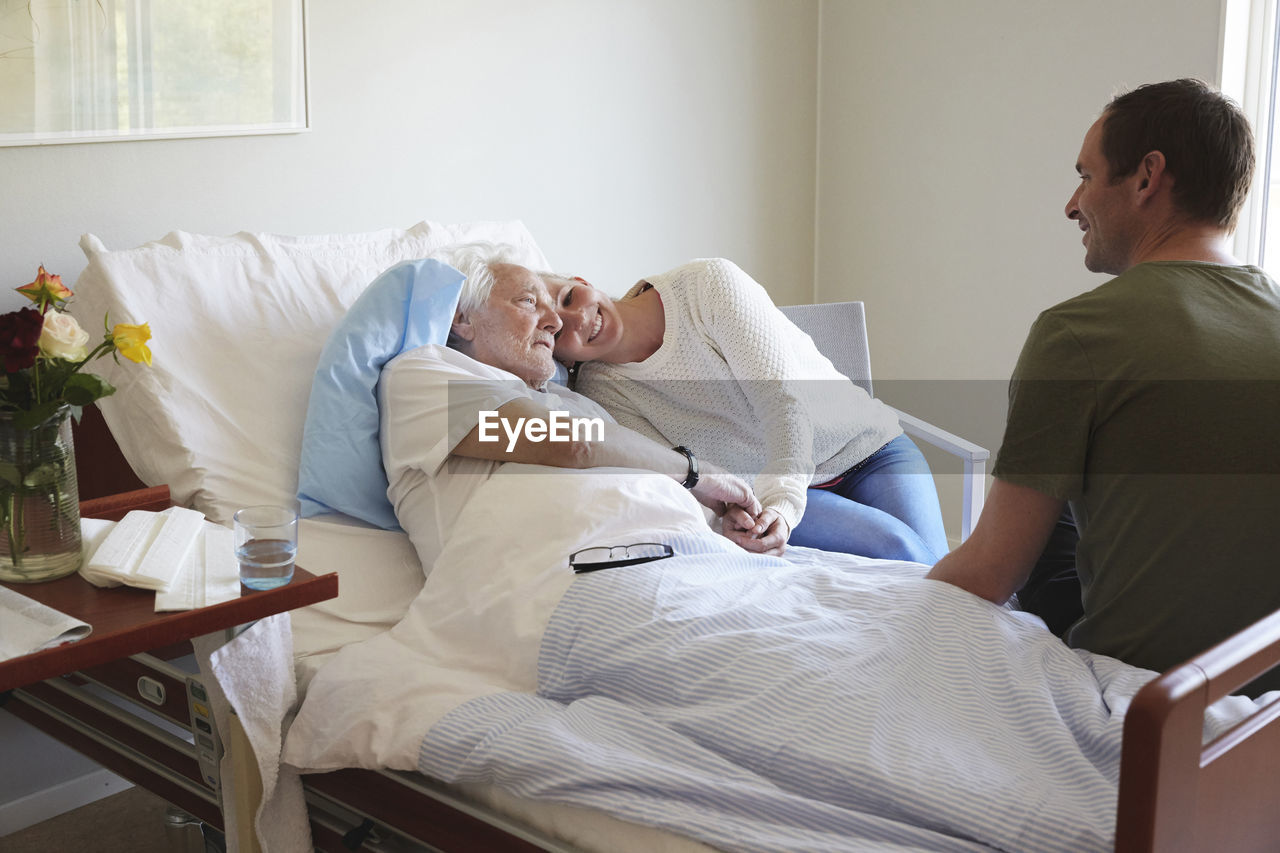 Couple visiting senior man in hospital