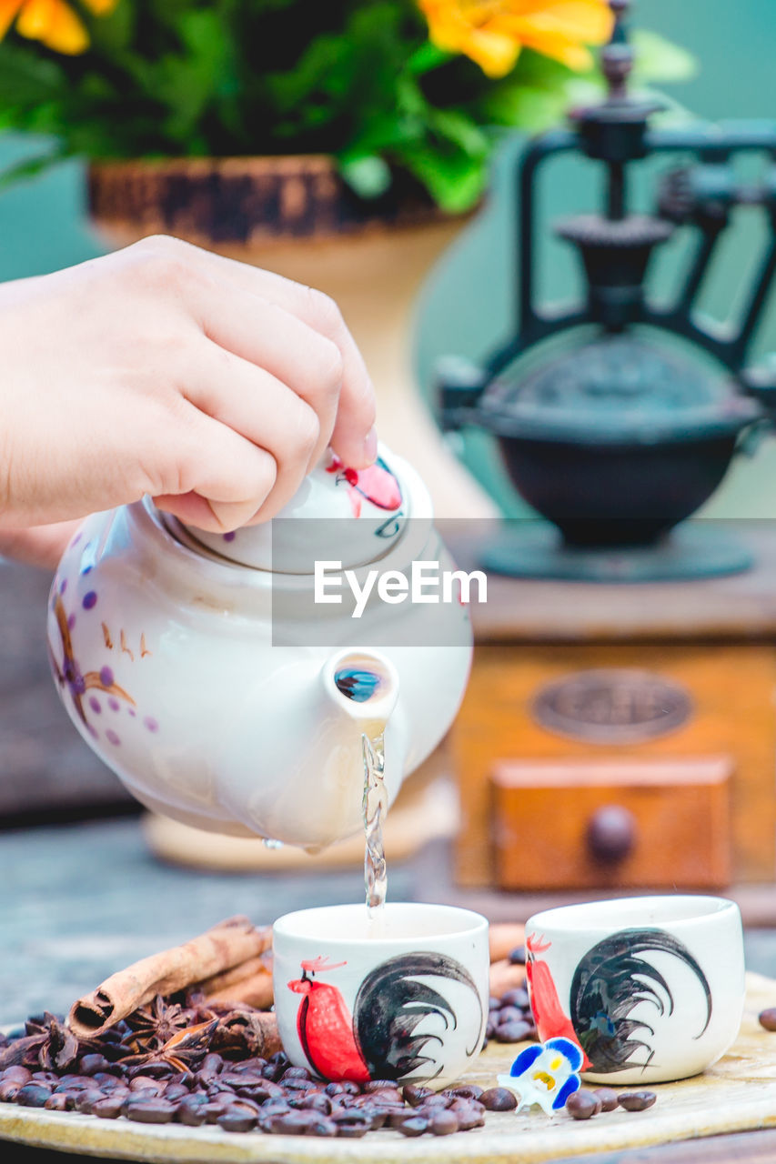 Cropped hand of person holding coffee on table