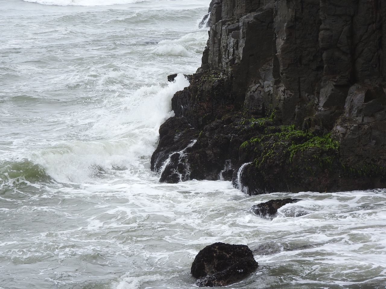 Wave splashing on rock formation in sea