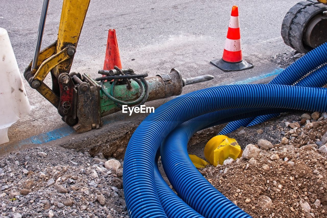 HIGH ANGLE VIEW OF YELLOW CONTAINER ON ROAD BY CONSTRUCTION SITE