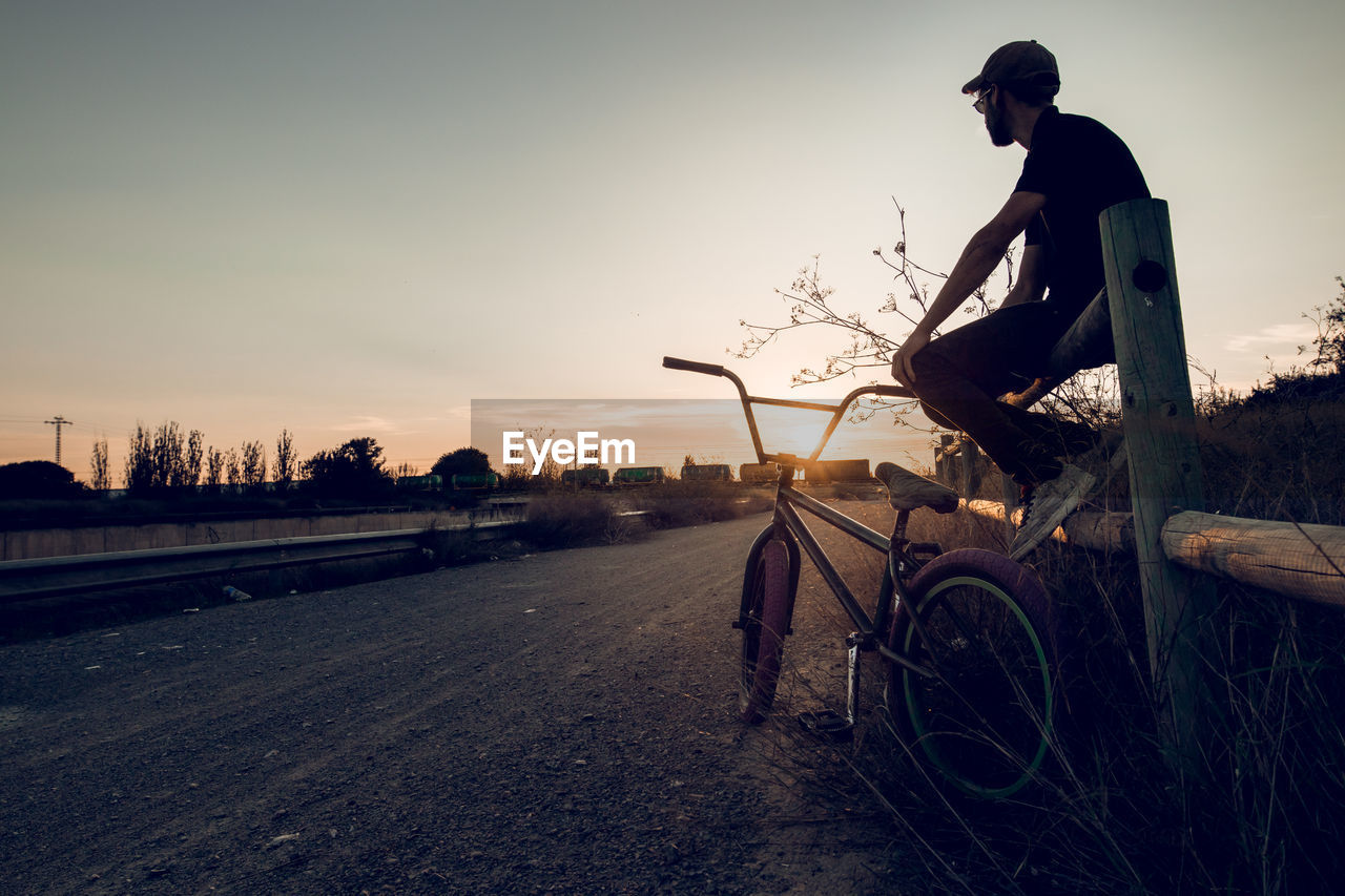 MAN RIDING BICYCLE ON ROAD