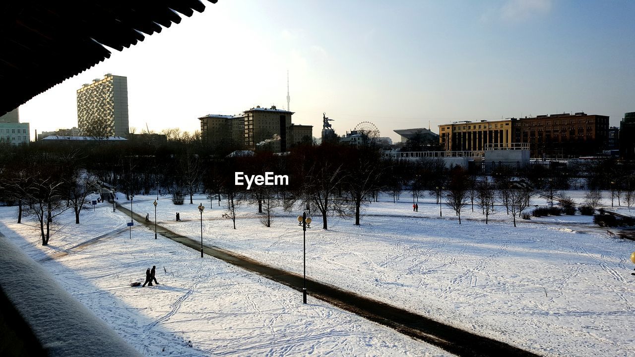 Buildings in city against clear during winter
