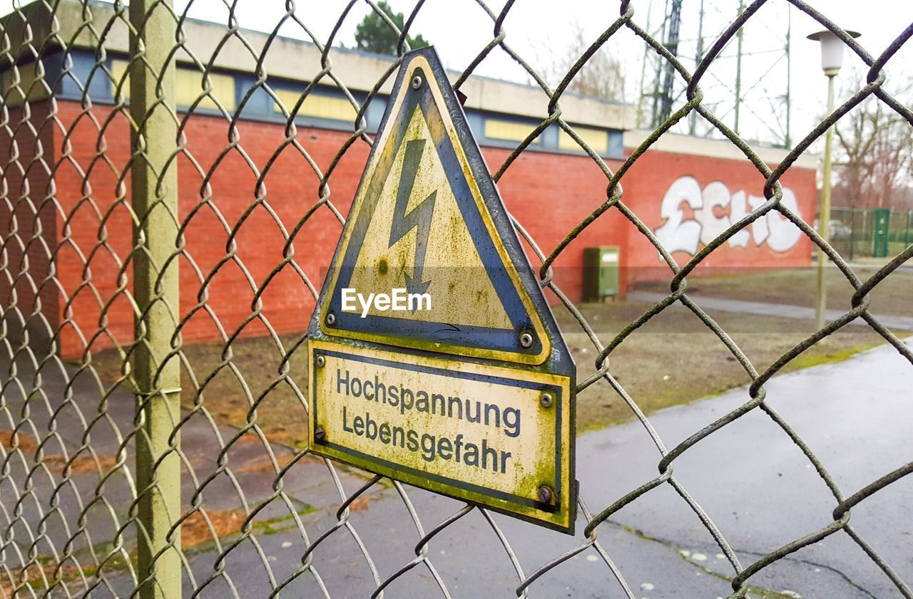 CLOSE-UP OF CHAINLINK FENCE AGAINST SKY