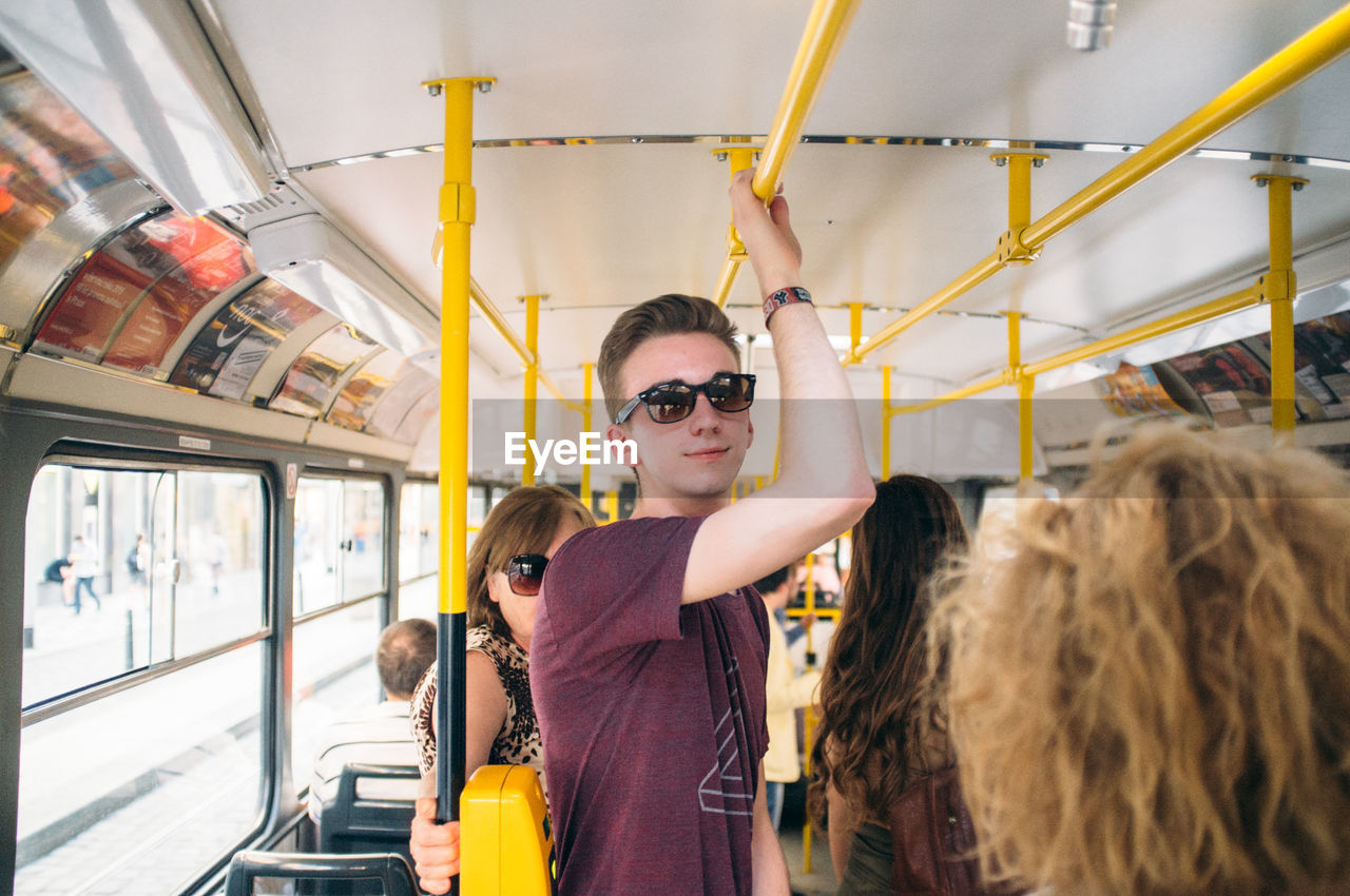Portrait of handsome young man standing in bus