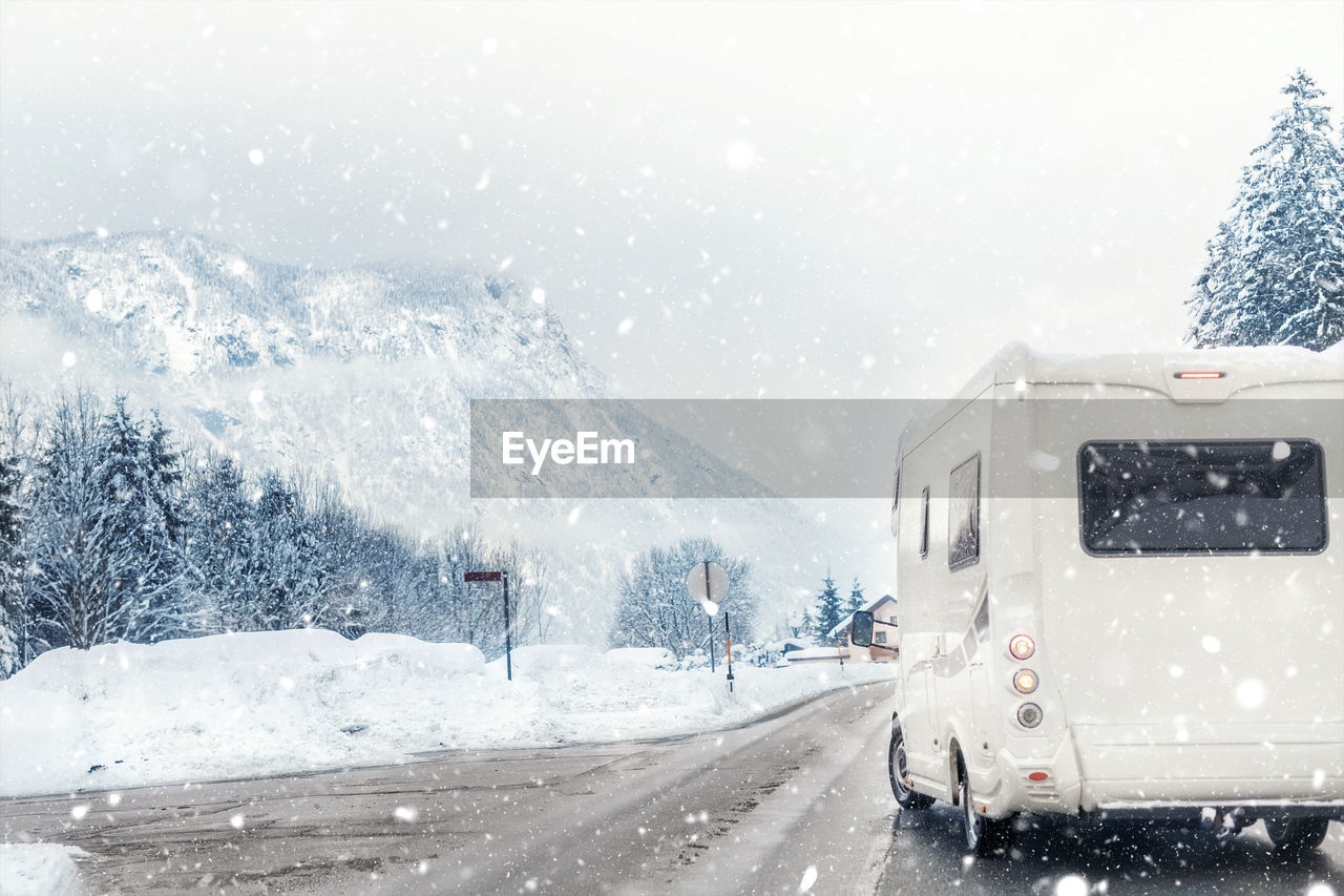 ROAD AMIDST SNOWCAPPED MOUNTAINS DURING WINTER