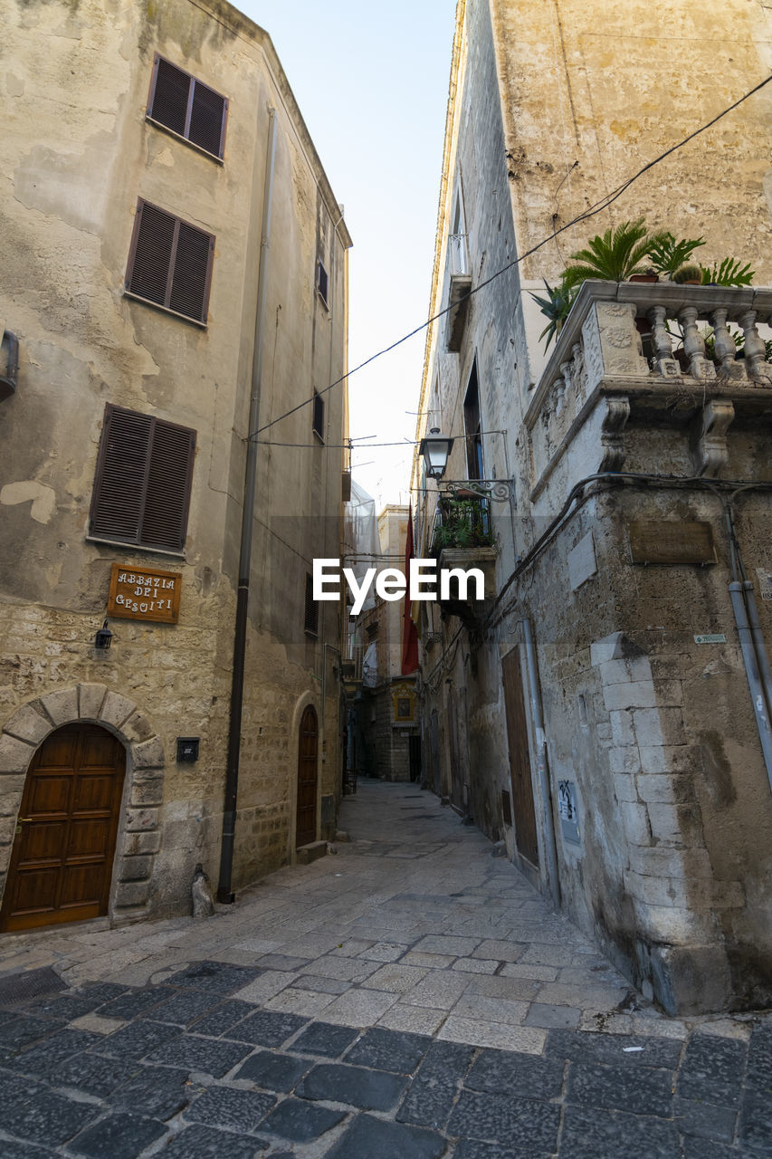 ALLEY AMIDST BUILDINGS IN CITY