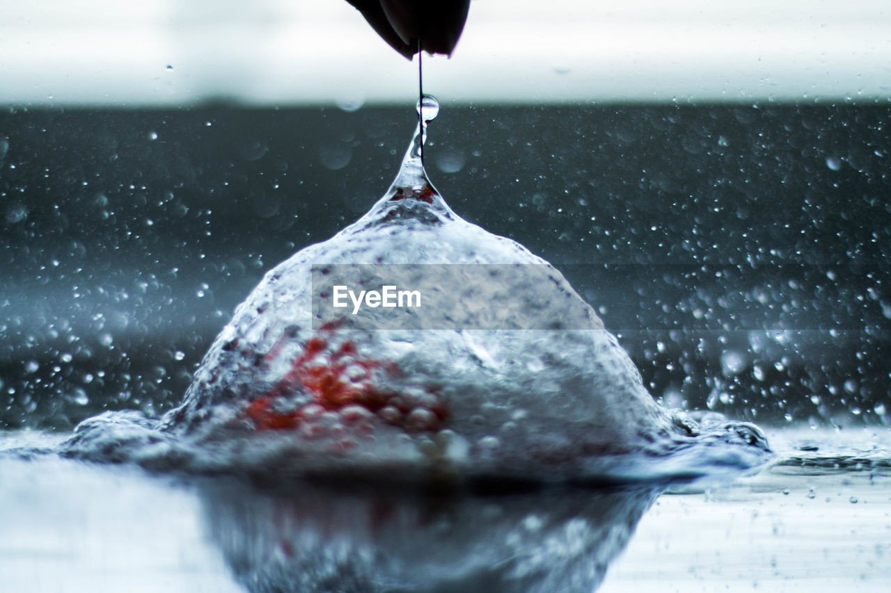 CLOSE-UP OF WATER DROPS ON ICE POURING