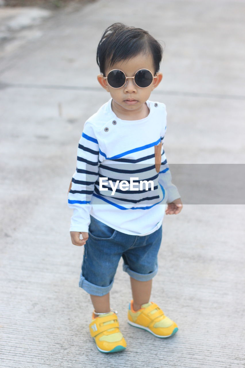 Asian boys wearing black fashion glasses and white striped shirts.