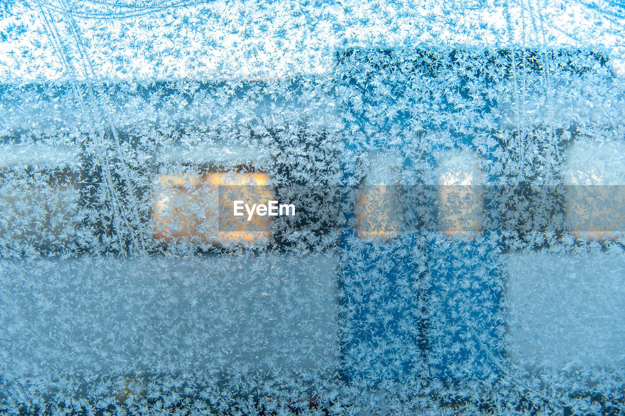 Full frame shot of snowflakes on window with commuter train in stockholm behind