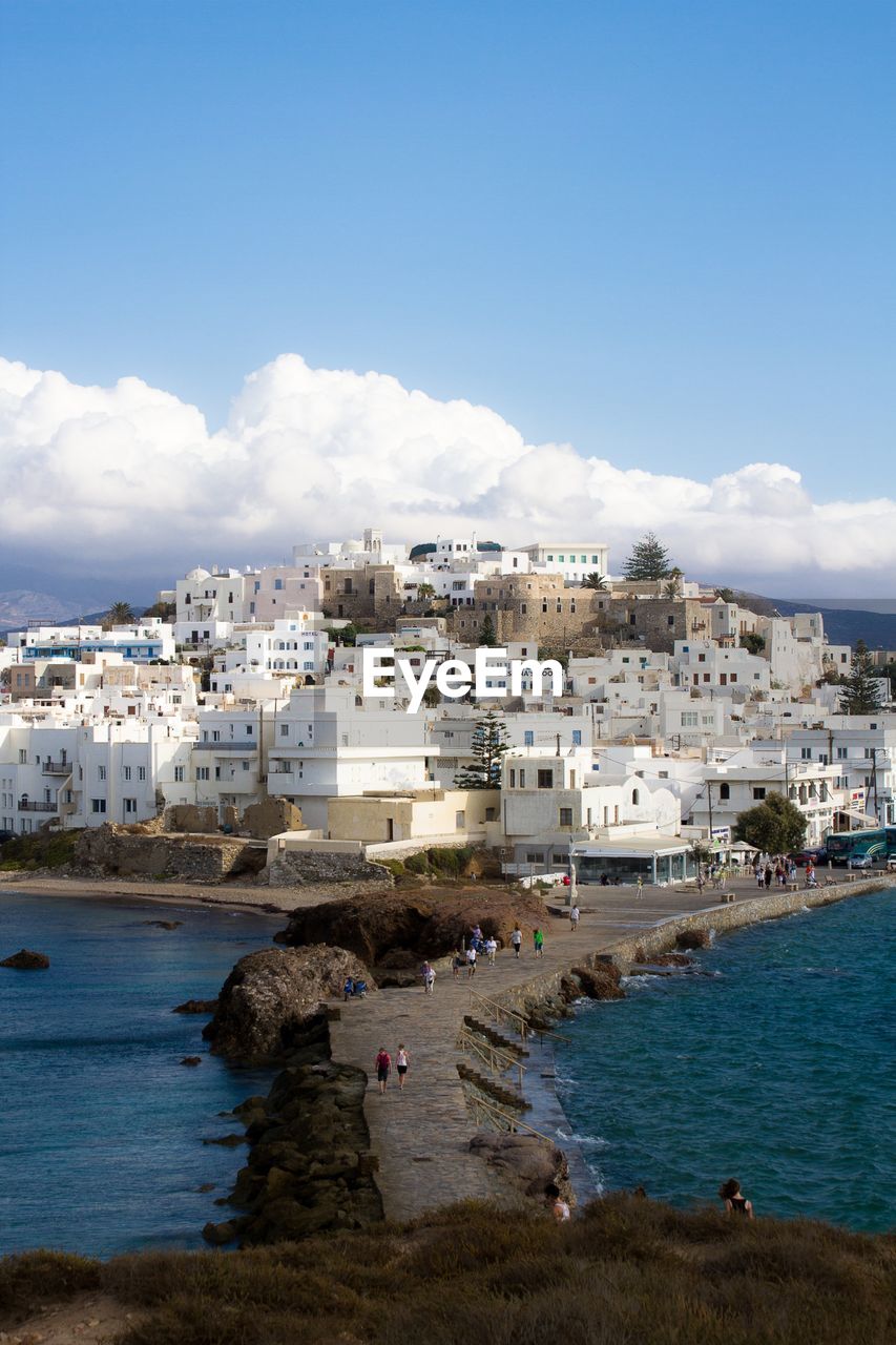 White houses in front of sea against sky in old town