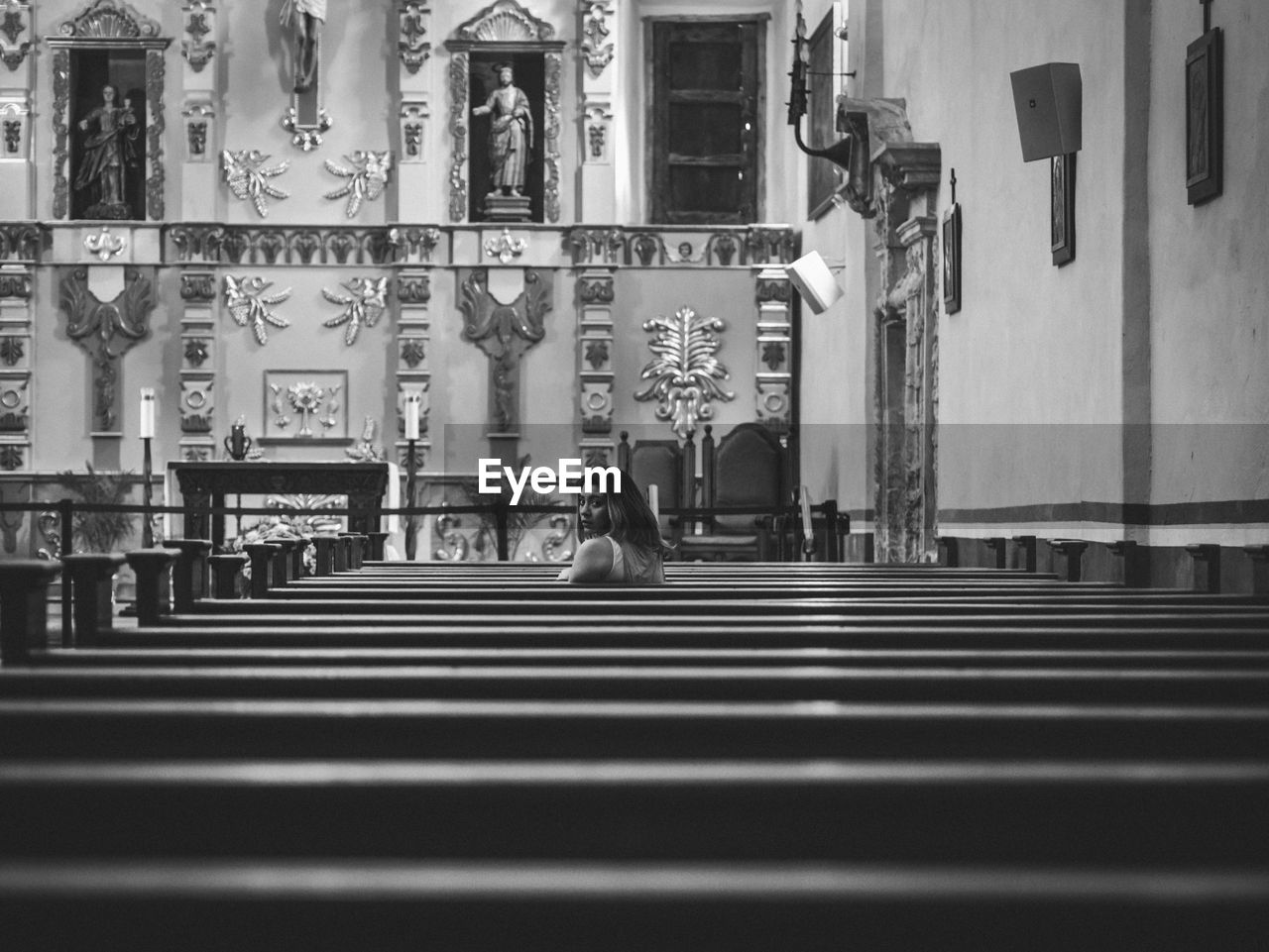 Woman sitting on pew at church