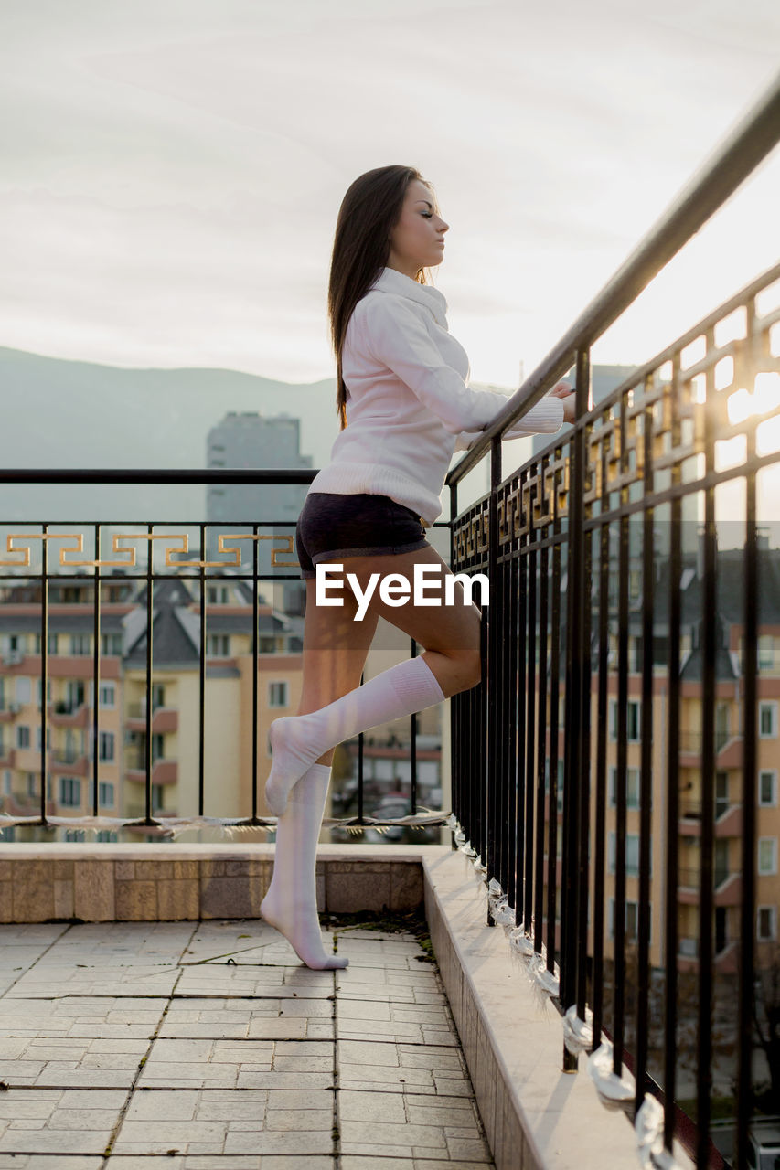 Young woman standing at balcony