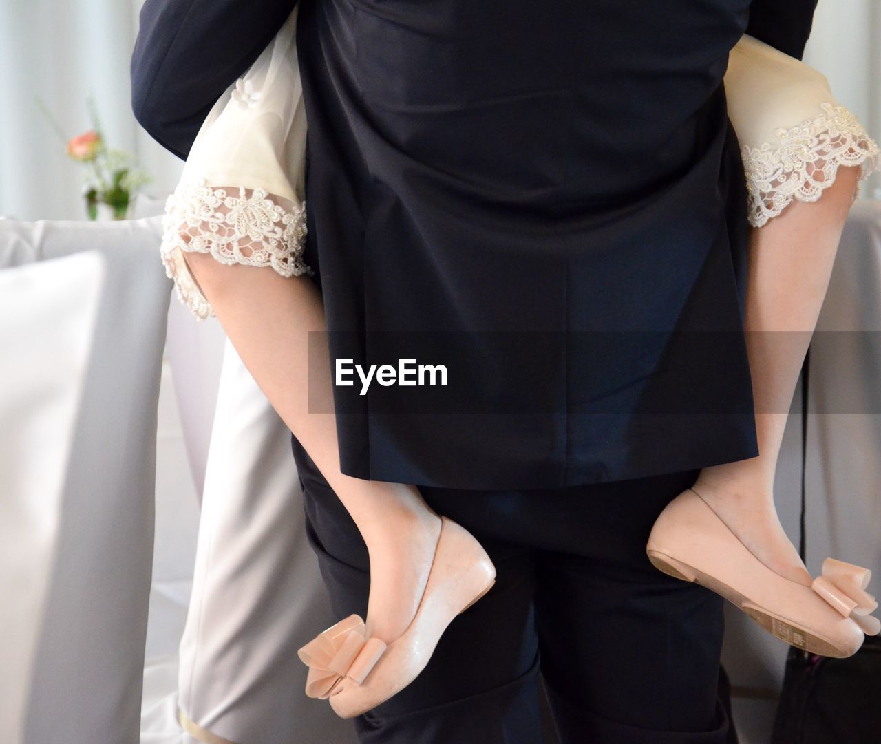 Rear view of groom embracing bride during wedding ceremony