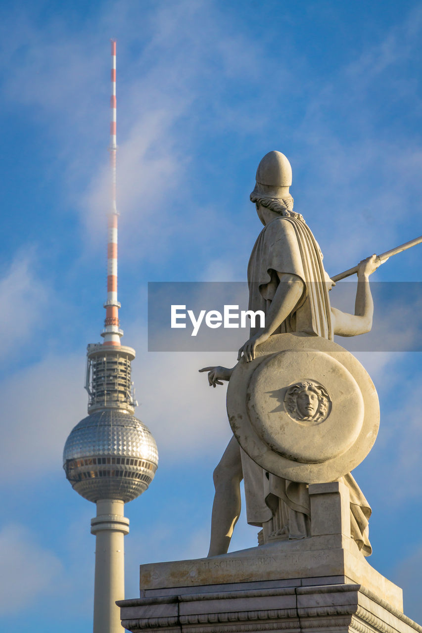 Low angle view of fernsehturm
 against cloudy sky