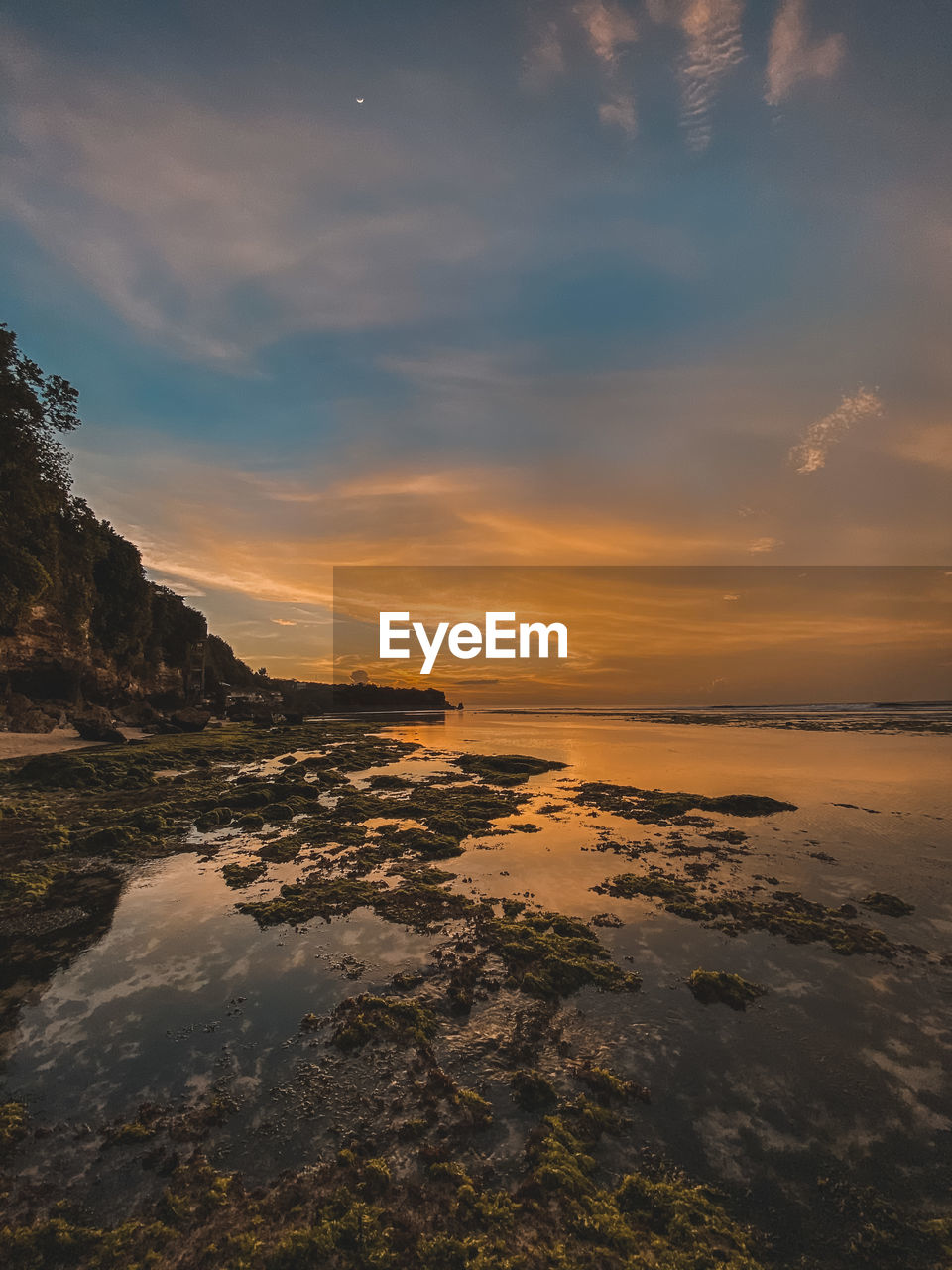 SCENIC VIEW OF BEACH AGAINST SKY AT SUNSET