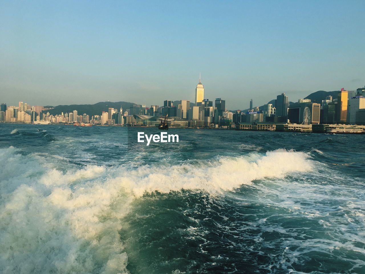 View of city at waterfront against clear sky