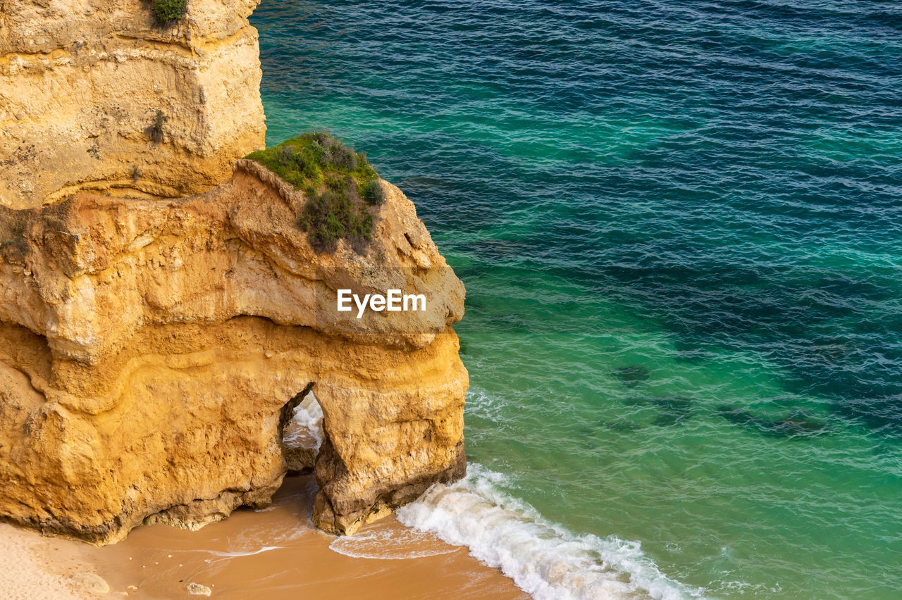 HIGH ANGLE VIEW OF ROCK FORMATION AT SEA