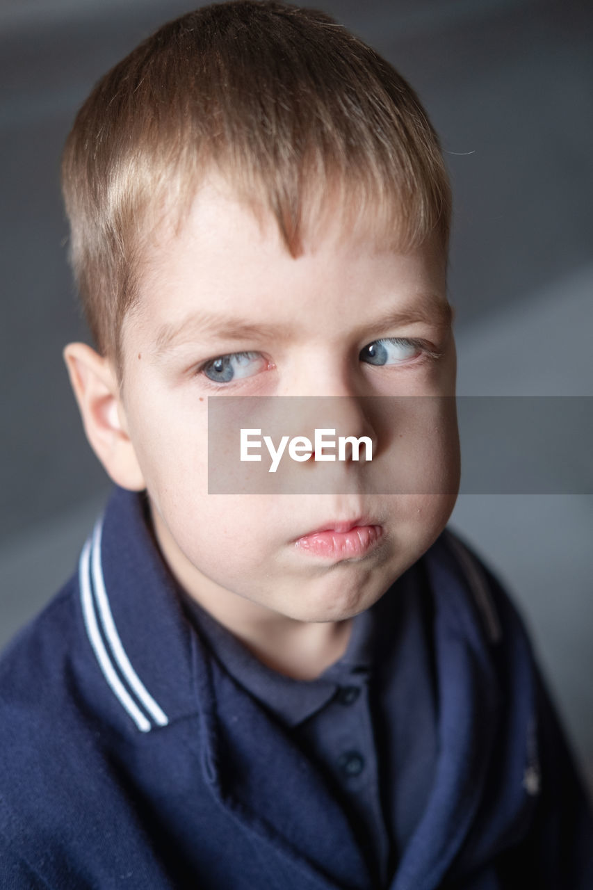 Portrait of a 6 year old boy with blond hair and blue eyes indoors