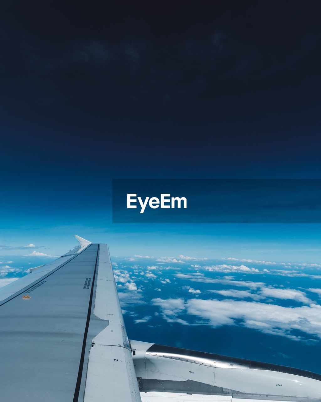 AERIAL VIEW OF AIRPLANE WING AGAINST SKY