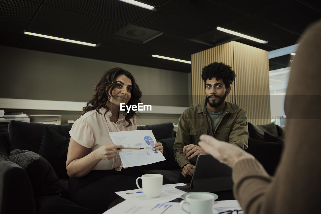 Group of business people analyzing charts during meeting in lobby