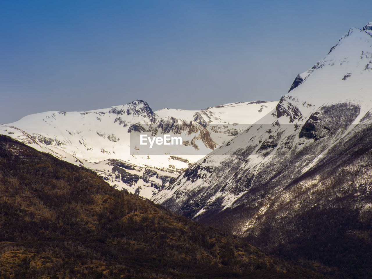 Scenic view of snowcapped mountains against clear sky