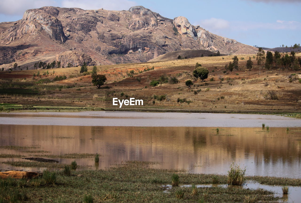 Scenic view of lake by mountain against sky