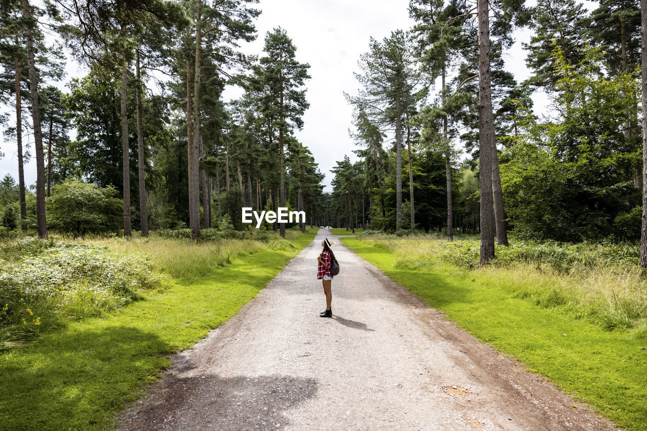 Woman standing on road in forest at cannock chase