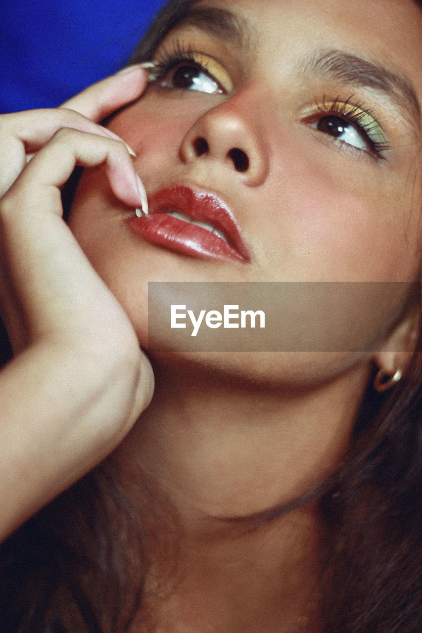 Close-up of thoughtful teenage girl with make-up looking away