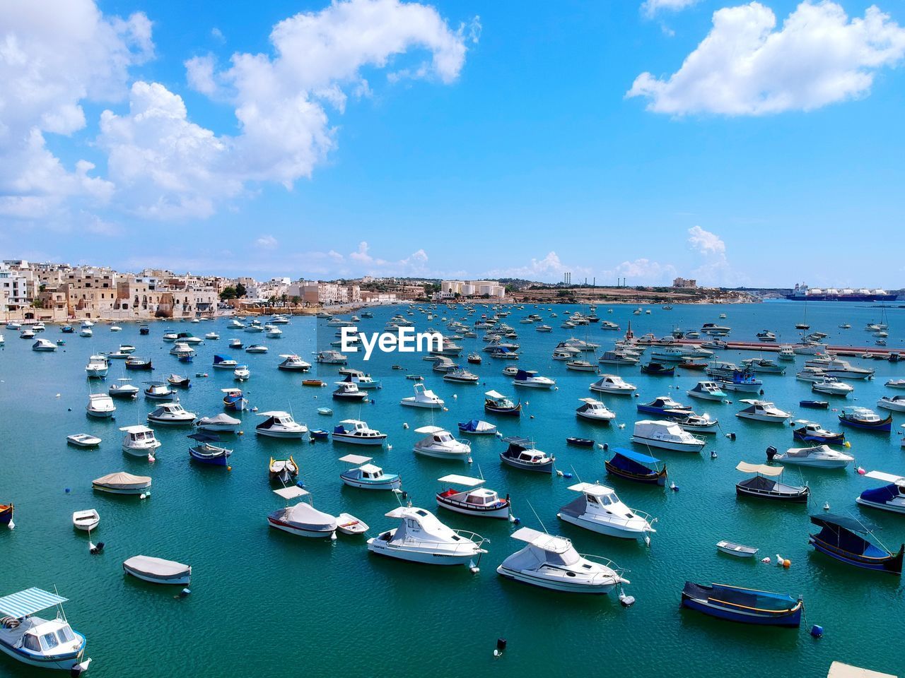 SAILBOATS MOORED ON SEA AGAINST BLUE SKY