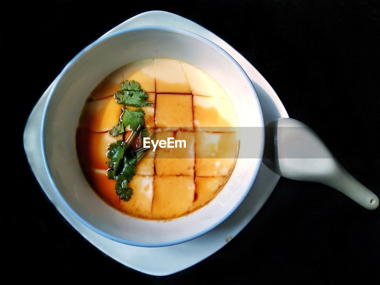 DIRECTLY ABOVE SHOT OF SOUP IN BOWL AGAINST BLACK BACKGROUND