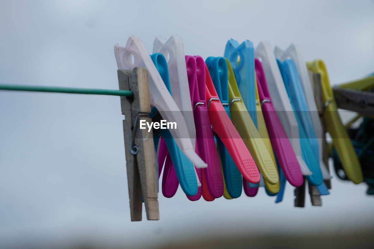 clothespin, hanging, clothesline, multi colored, large group of objects, no people, variation, in a row, group of objects, drying, laundry, clothing, blue, close-up, side by side, focus on foreground, clip, day, sky, still life