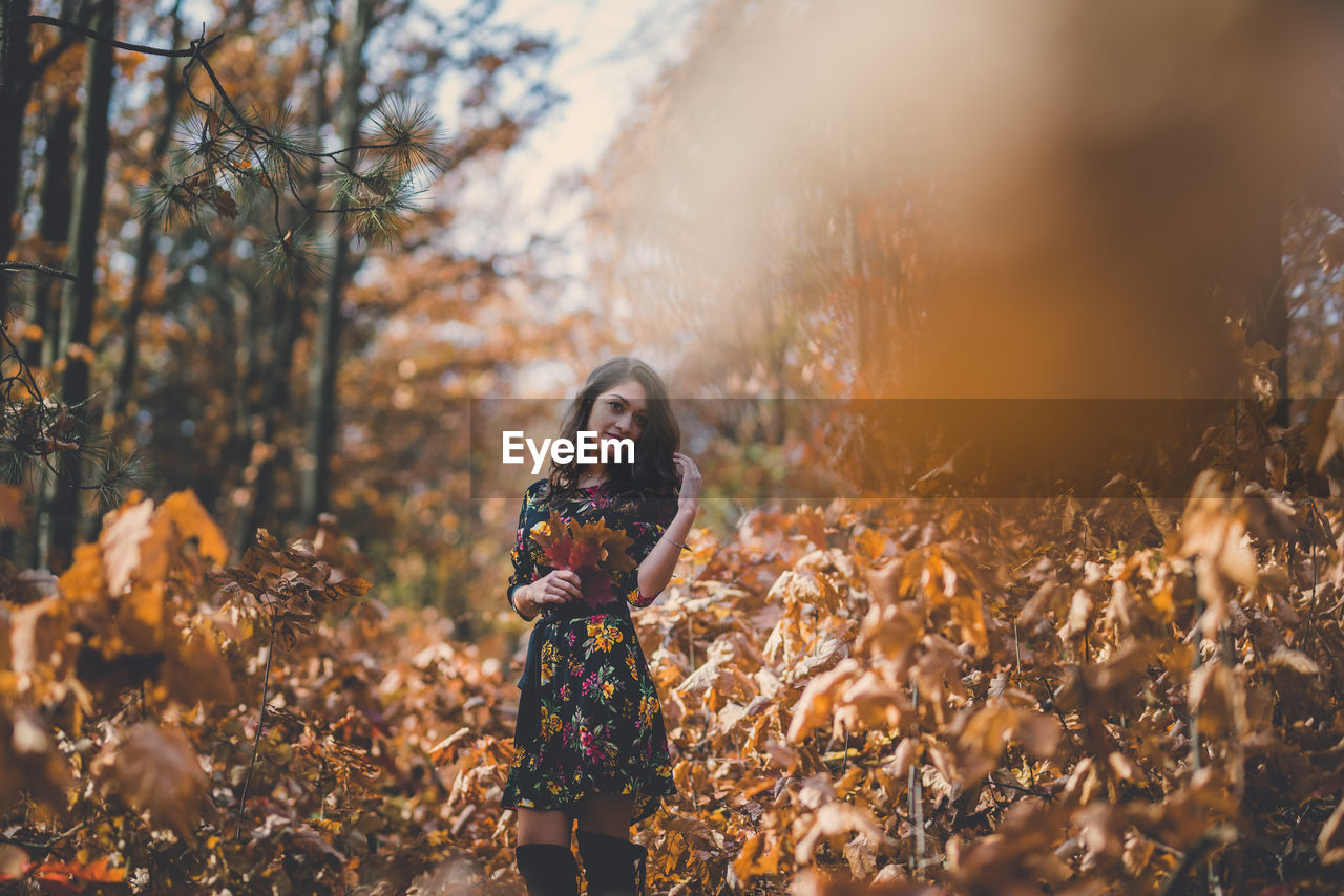 Woman standing on field in forest