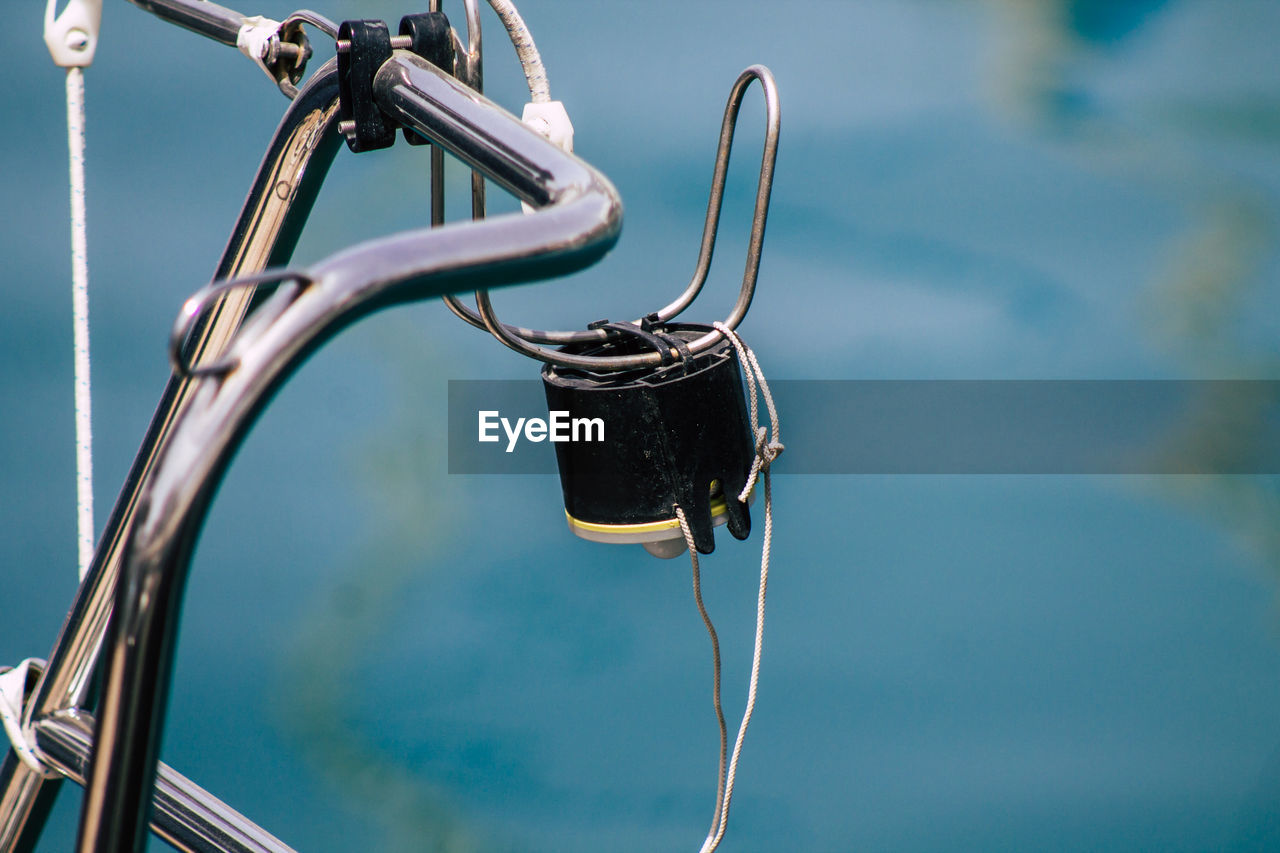 CLOSE-UP OF METAL CHAIN AGAINST SEA