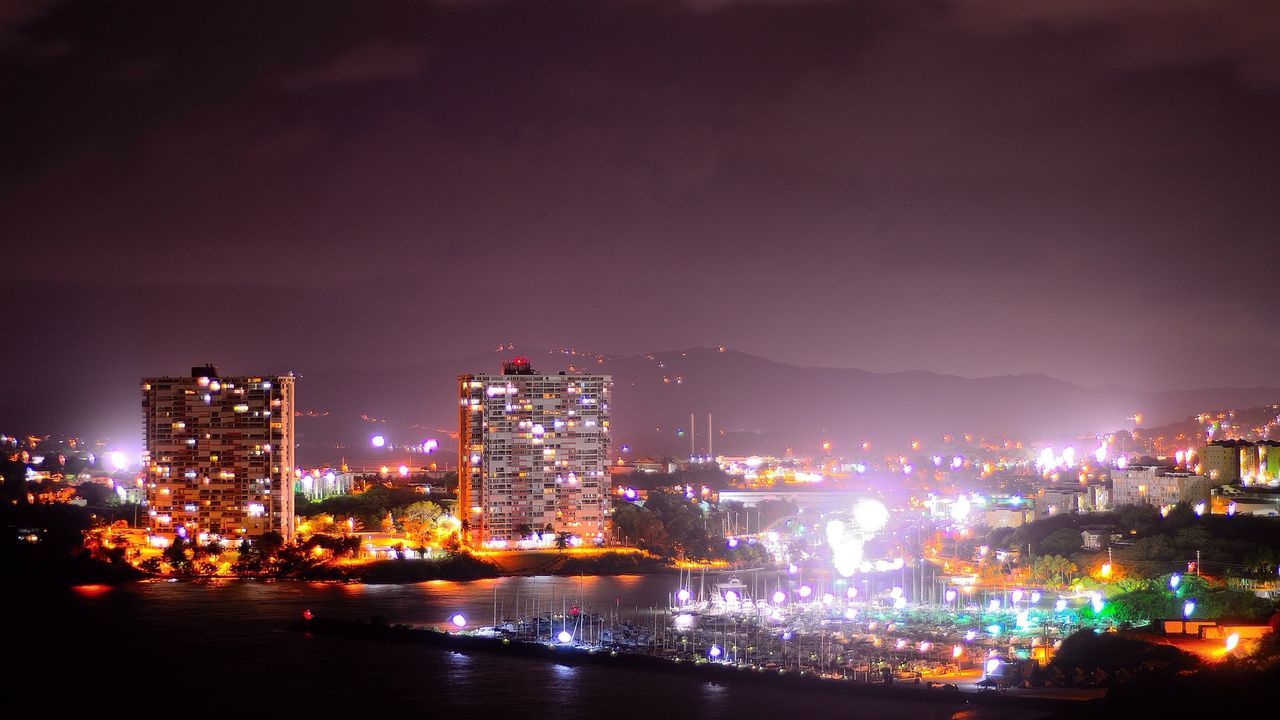 High angle view of commercial dock with city lit up at night