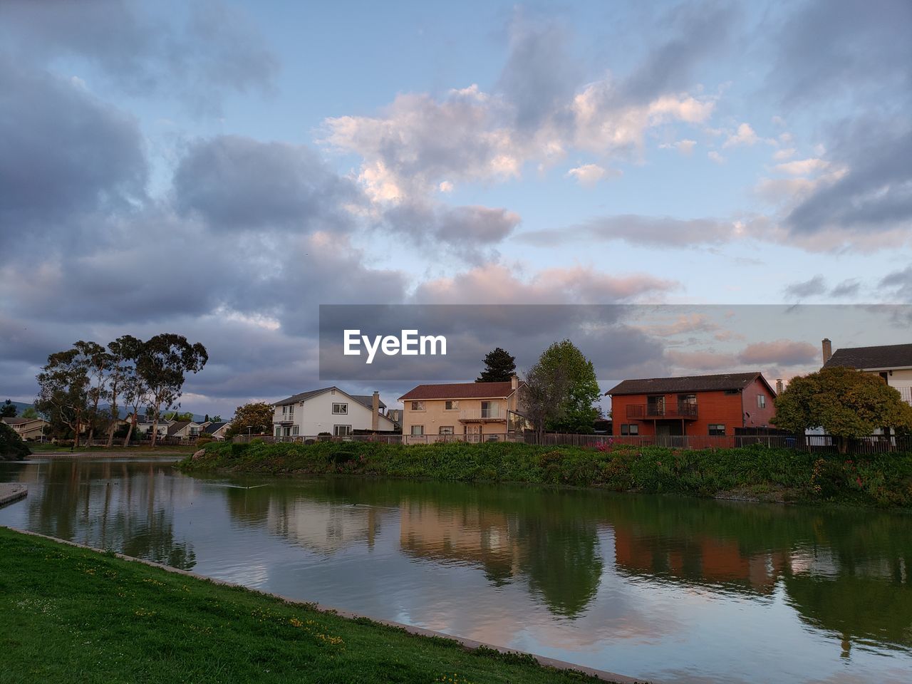 HOUSES BY LAKE AGAINST SKY