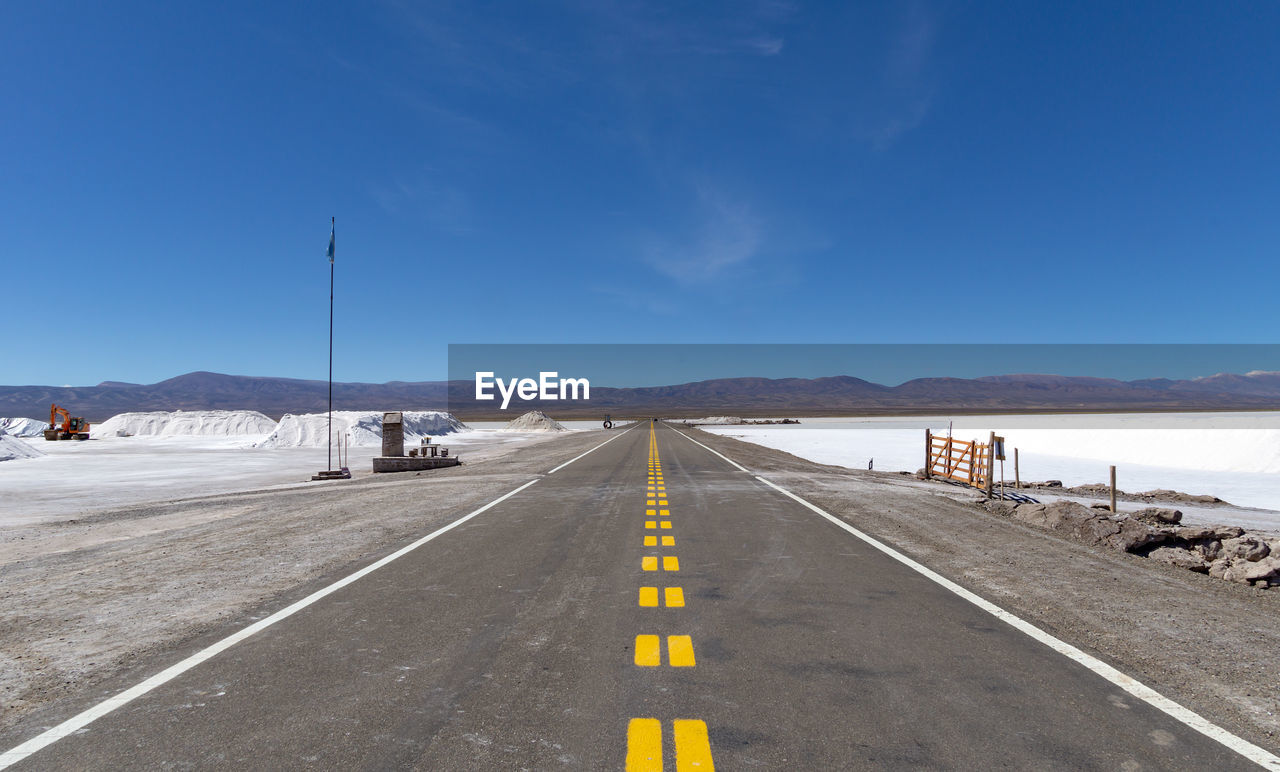 ROAD BY MOUNTAINS AGAINST SKY