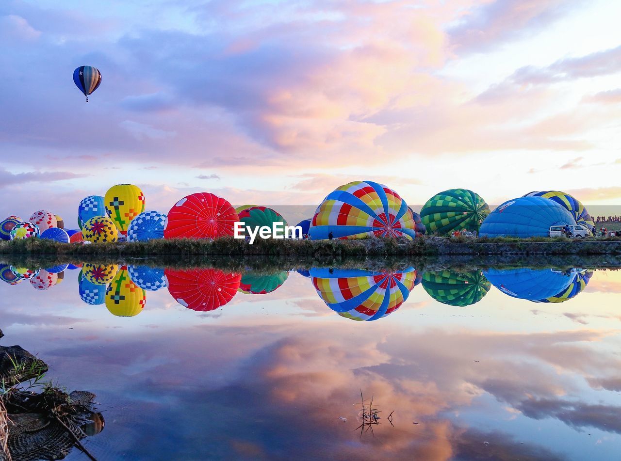 Multi colored reflection in lake against sky during sunset